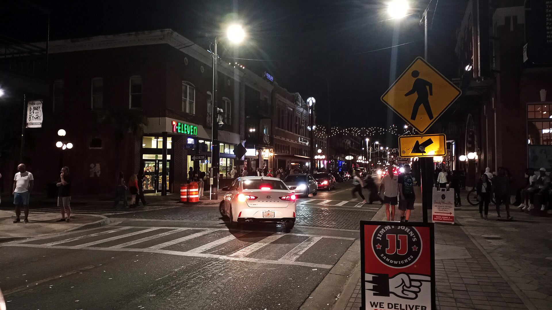 A downtown street corner lit at night